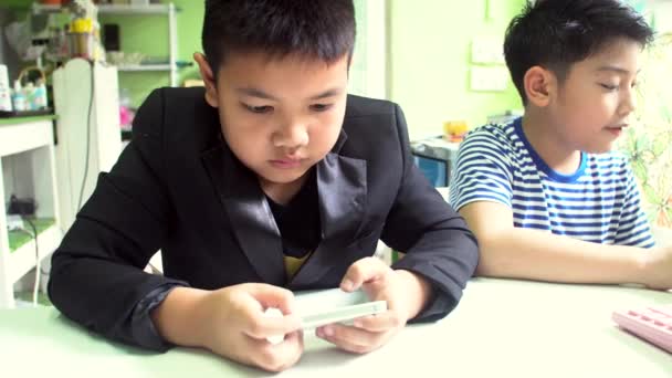 年轻快乐的亚洲男孩玩手机和平板电脑 . — 图库视频影像