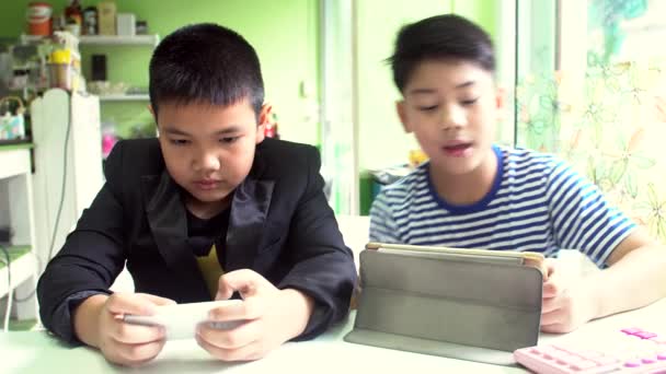 Junge glücklich asiatische zwei Jungen spielen Spiel mit Handy und Tablet-Computer . — Stockvideo