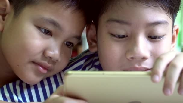 年轻快乐的亚洲男孩玩手机和平板电脑 . — 图库视频影像