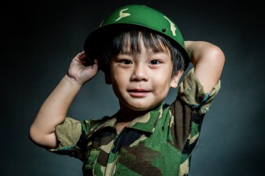 Bir asker gibi giyinmiş genç Asyalı çocuk