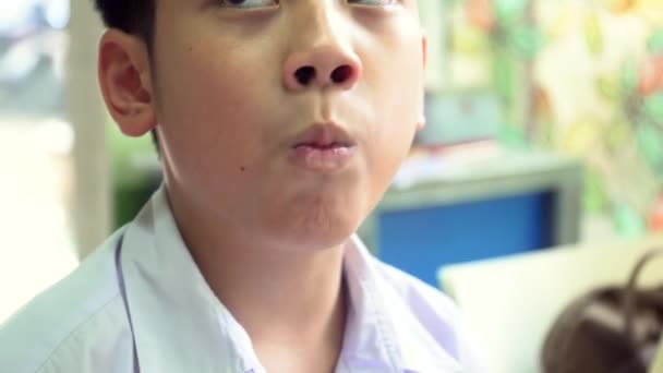 Küçük Asyalı çocuk yemek ve televizyon izlerken seviyor — Stok video