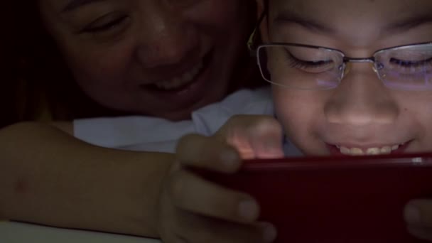 Счастливые мать и сын из Азии вместе пользуются цифровой табличкой  . — стоковое видео