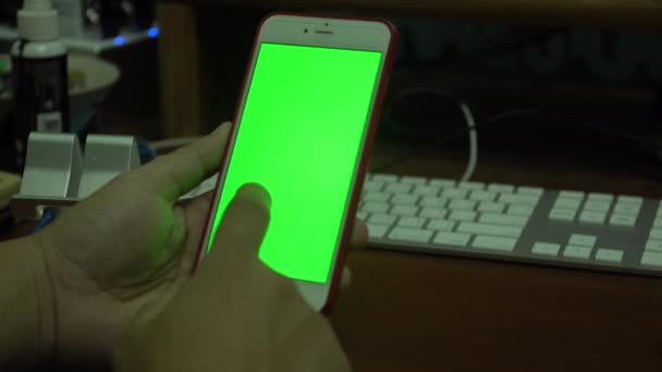 Weibliche Hand mit einem Smartphone mit grünem Bildschirm — Stockvideo