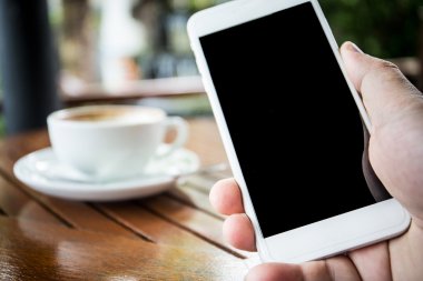 Telefonunuzun ve boş siyah perde ve kahve cu ile Smartphonehand