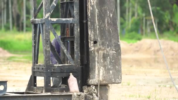 Piloto em um canteiro de obras, um poste que suporta uma pilha de vigas — Vídeo de Stock