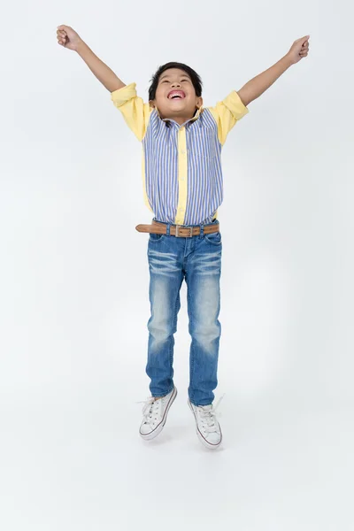 Щасливий азіатський хлопчик стрибає — стокове фото