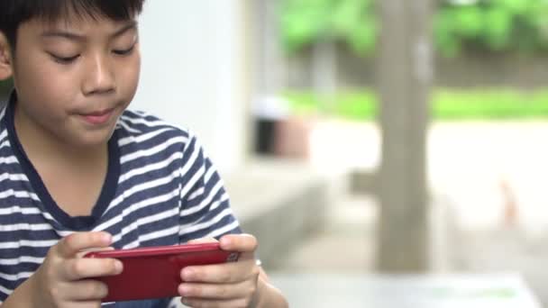 Ασίας αγόρι χρησιμοποιώντας έξυπνο κινητό τηλέφωνο κοντά στο δρόμο, Μπανγκόκ Ταϊλάνδη — Αρχείο Βίντεο