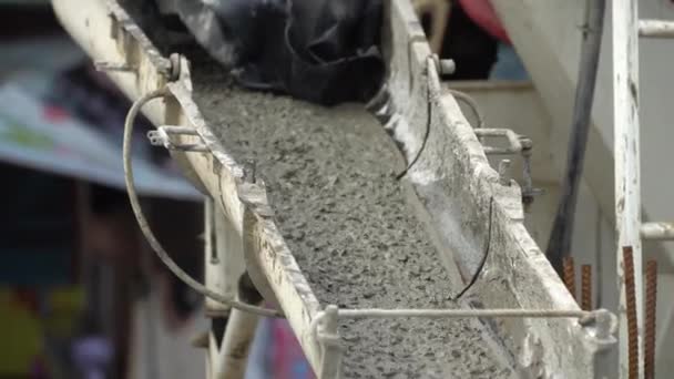 Pekerja konstruksi tidak dikenal menuangkan campuran beton dari pencampur semen . — Stok Video