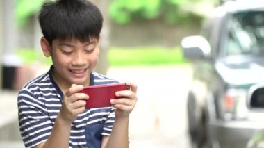 Asyalı çocuk road, Bangkok Tayland yakınındaki akıllı cep telefonu kullanarak