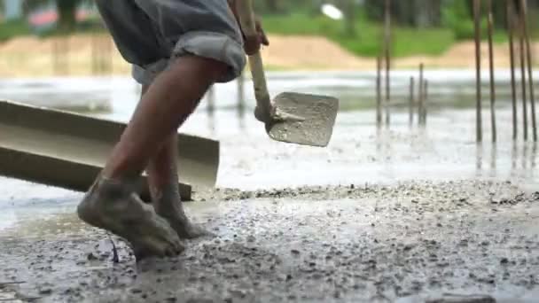 Unbekannte Bauarbeiter gießen Betonmischung aus Zementmischer. — Stockvideo