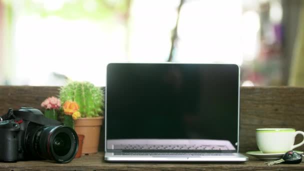 Escritorio de madera con un ordenador portátil, Lugar de trabajo al aire libre bajo un gran árbol . — Vídeo de stock