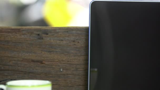 Escritorio de madera con un ordenador portátil, Lugar de trabajo al aire libre bajo un gran árbol . — Vídeo de stock