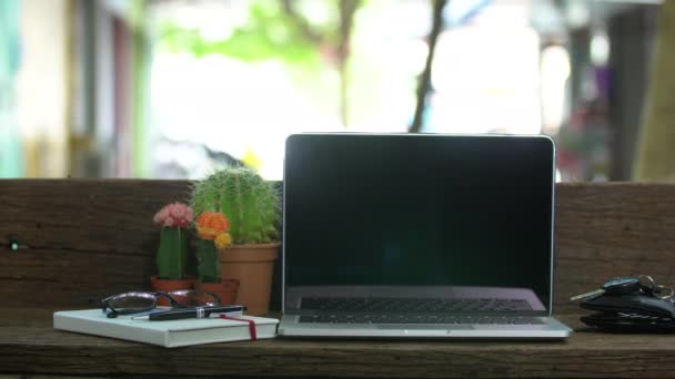 Wood desk with a laptop ,Outdoor workplace under big tree. — Stock Video