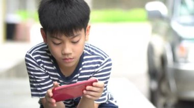 Asyalı çocuk road, Bangkok Tayland yakınındaki akıllı cep telefonu kullanarak