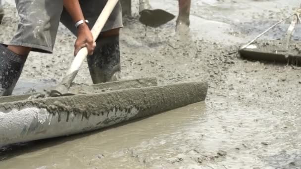 Nicht identifizierbare Bauarbeiter gießen Betonmischung aus Zementmischer.Zeitlupe 120 fps. — Stockvideo