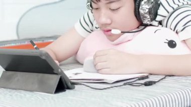 Asyalı çocuk yalan söylüyorum, çiziyorum ve evdeki tablet bilgisayarımdan müzik dinliyorum..