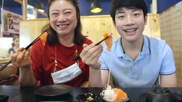 Azjatycka Rodzina Odwiedza Koreańską Restaurację Grillową Jedząc Sushi Łososiowe Uśmiechem — Wideo stockowe