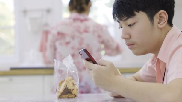 Азиатский Старшеклассник Играет Онлайн Игру Мобильном Телефоне Дома — стоковое видео