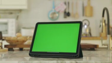Yeşil ekran krom anahtarı olan tablet. Evdeki mutfakta..