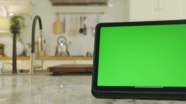 Yeşil ekran krom anahtarı olan tablet. Evdeki mutfakta..