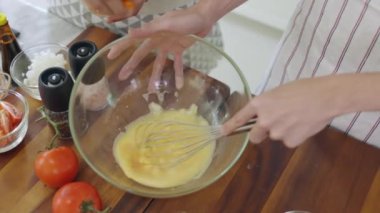 Bir çift evde sabah omleti yapmak için yumurta kırıyor. Yeni evli bir çift için romantik bir zaman. Yavaş çekim..