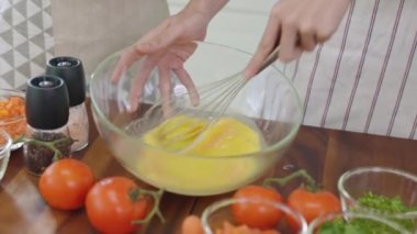 Bir çift evde sabah omleti yapmak için yumurta kırıyor. Yeni evli bir çift için romantik bir zaman. Yavaş çekim..