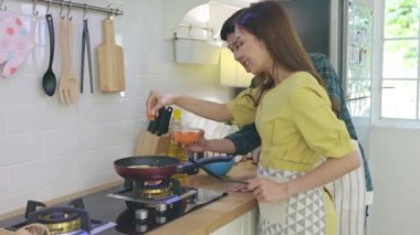 Genç evli çift evde romantik bir ortamda yemek pişirmeye yardım ediyor. Çiftler aşklarını kahvaltıda birbirlerine yardım ederek gösterirler..