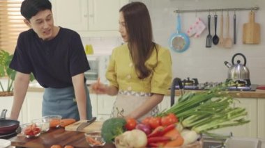 Yeni evli bir çift, mutlu bir şekilde yemek pişirmek ve evde eğlenmek için birbirlerine yardım ederler. Çiftler birlikte güzel, mutlu yemekler yaparak vakit geçirirler..