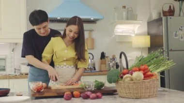 Yeni evli bir çift, mutlu bir şekilde yemek pişirmek ve evde eğlenmek için birbirlerine yardım ederler. Çiftler birlikte güzel, mutlu yemekler yaparak vakit geçirirler..