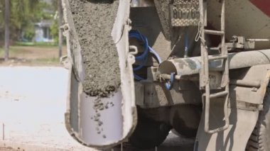 Karıştırıcı çimento kamyonundan akan ve dökülen beton inşaat alanındaki iş yoluna sıvı beton döküyor..