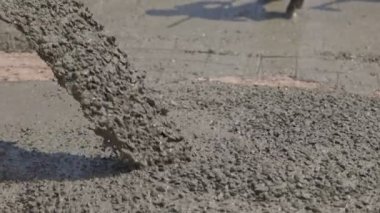 Karıştırıcı çimento kamyonundan akan ve dökülen beton inşaat alanındaki iş yoluna sıvı beton döküyor..