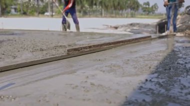 İşçiler yollar inşa ediyor. İşçiler arka plana odaklanmadan yol yapıyorlar.