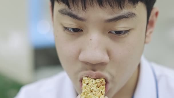 Ásia Teen Menino Comer Lanches Enquanto Usando Telefone Mesmo Tempo — Vídeo de Stock