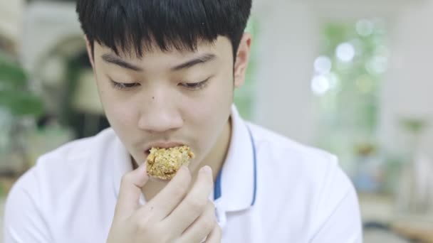 Azji Nastolatek Chłopiec Jedzenie Przekąski Podczas Korzystania Telefonu Tym Samym — Wideo stockowe