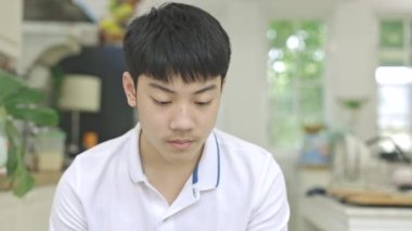 Asyalı çocuğun portresi 4K UHD 'de gülümseyen yüzüyle kameraya bakarken destek kullan.