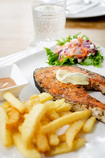 Grilled salmon steak served with salad, chips, — Stock Photo, Image