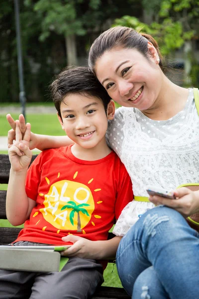 Vacker asiatisk kvinna med din son i parken — Stockfoto