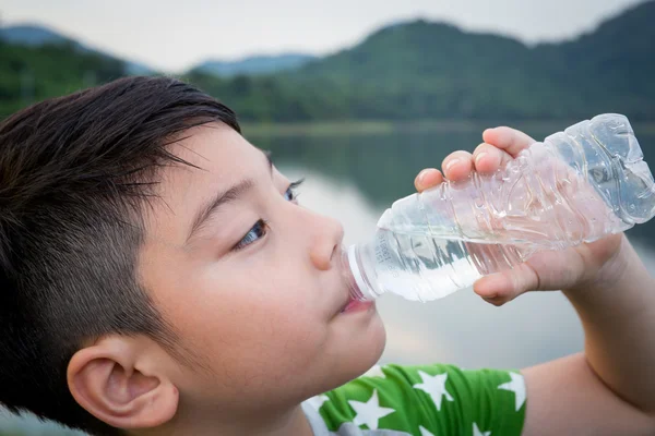 Niño bebiendo agua mineral — Foto de Stock