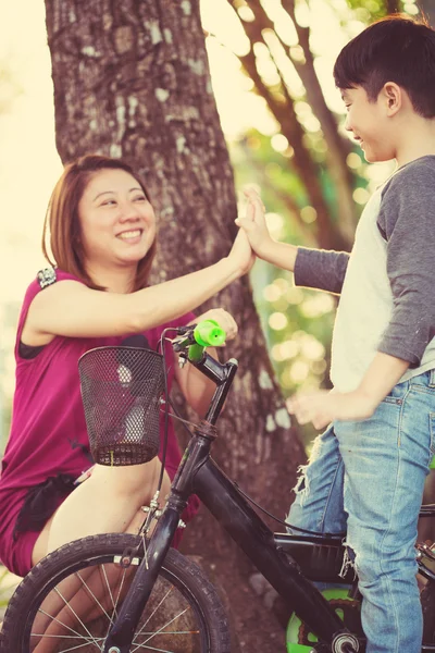 Little Asian child with mother practice to riding a bicycle — Stock Photo, Image