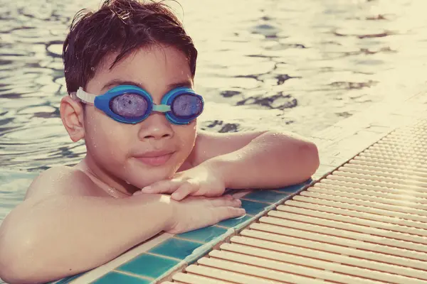 Porträt eines glücklichen kleinen Jungen, der im Pool spielt — Stockfoto