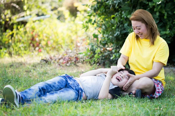 Счастливая азиатская мама с милым маленьким мальчиком в парке — стоковое фото