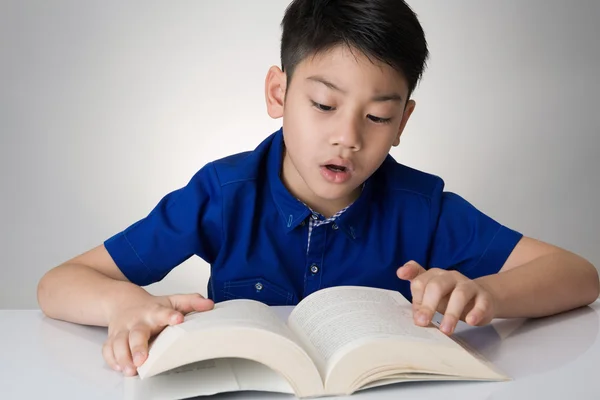 Liten asiatisk pojke läsa en bok — Stockfoto