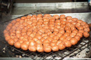 Tay tarzında ızgara sosis bir soba üzerinde yuvarlak.