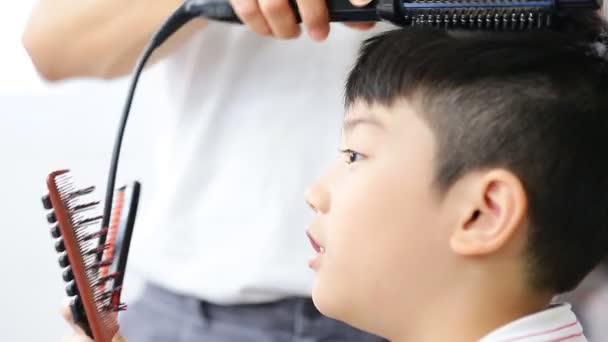 Ασιατικές χαριτωμένο αγόρι κάνει σε ένα κομμωτήριο, υφολογικά αγνώστων μαλλιά — Αρχείο Βίντεο