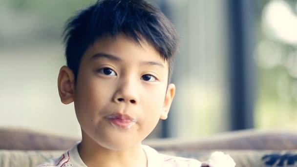 Маленький азиатский милый мальчик наслаждается мороженым — стоковое видео