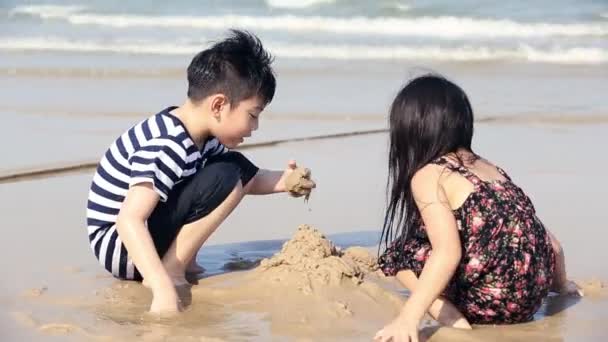 Primer plano de asiático chico y chica Duro en trabajo, construcción de castillos en la arena playa — Vídeos de Stock