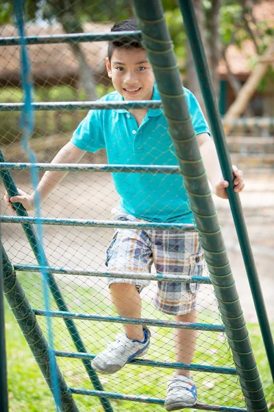 Счастливый азиатский милый мальчик играет на детской площадке — стоковое фото