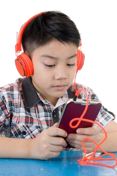アジアの少年ウェア ヘッドフォンと携帯電話を再生 — ストック写真