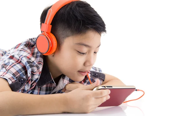 Asijské boy konzumní sluchátka a hraje na mobilní telefon — Stock fotografie