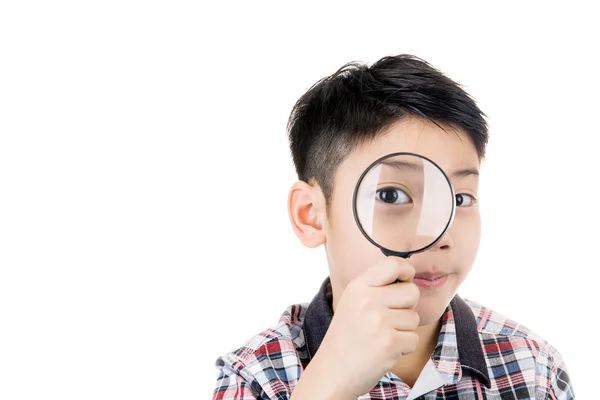 Porträtt av en ung asiatiska barn tittar genom ett förstoringsglas gla — Stockfoto